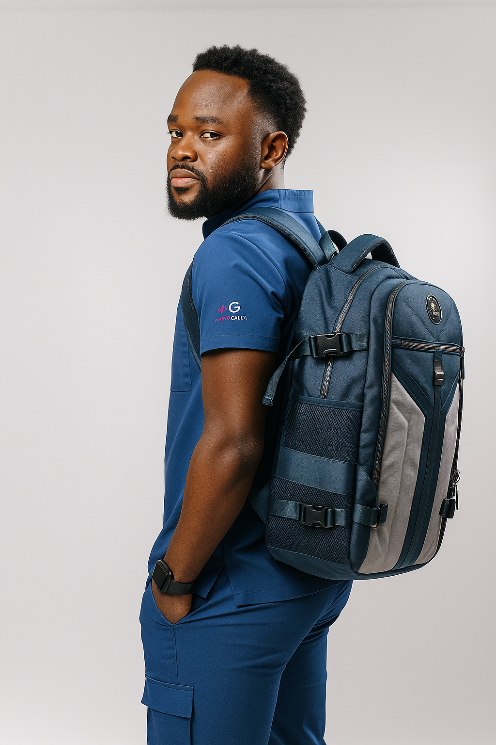 Man wearing MG Aviator IJ backpack in blue and gray with MoxieGalia premium scrubs against a neutral background