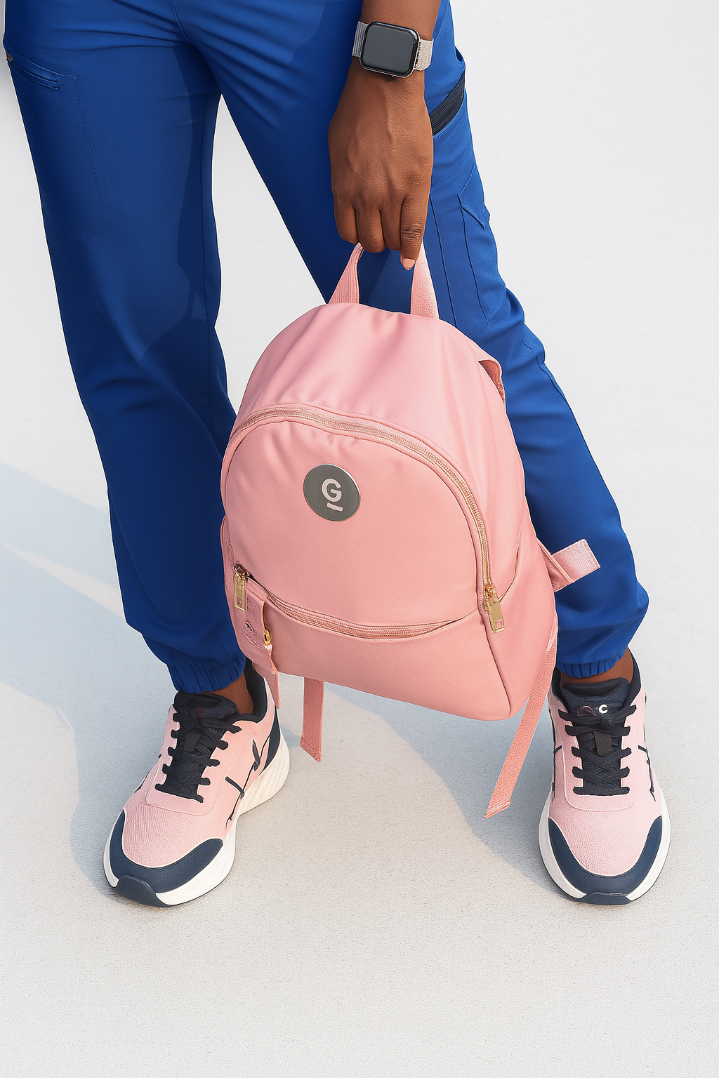 MG Voltrèa LTE pink sneakers with MG Blush Jet backpack held by medical professional in MG premium blue scrubs on white background