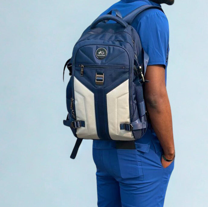 Doctor wearing MoxieGalia MG Aviator IJ backpack in navy and gray, styled with moxiegalia scrubs, ideal for work, travel, or daily use”