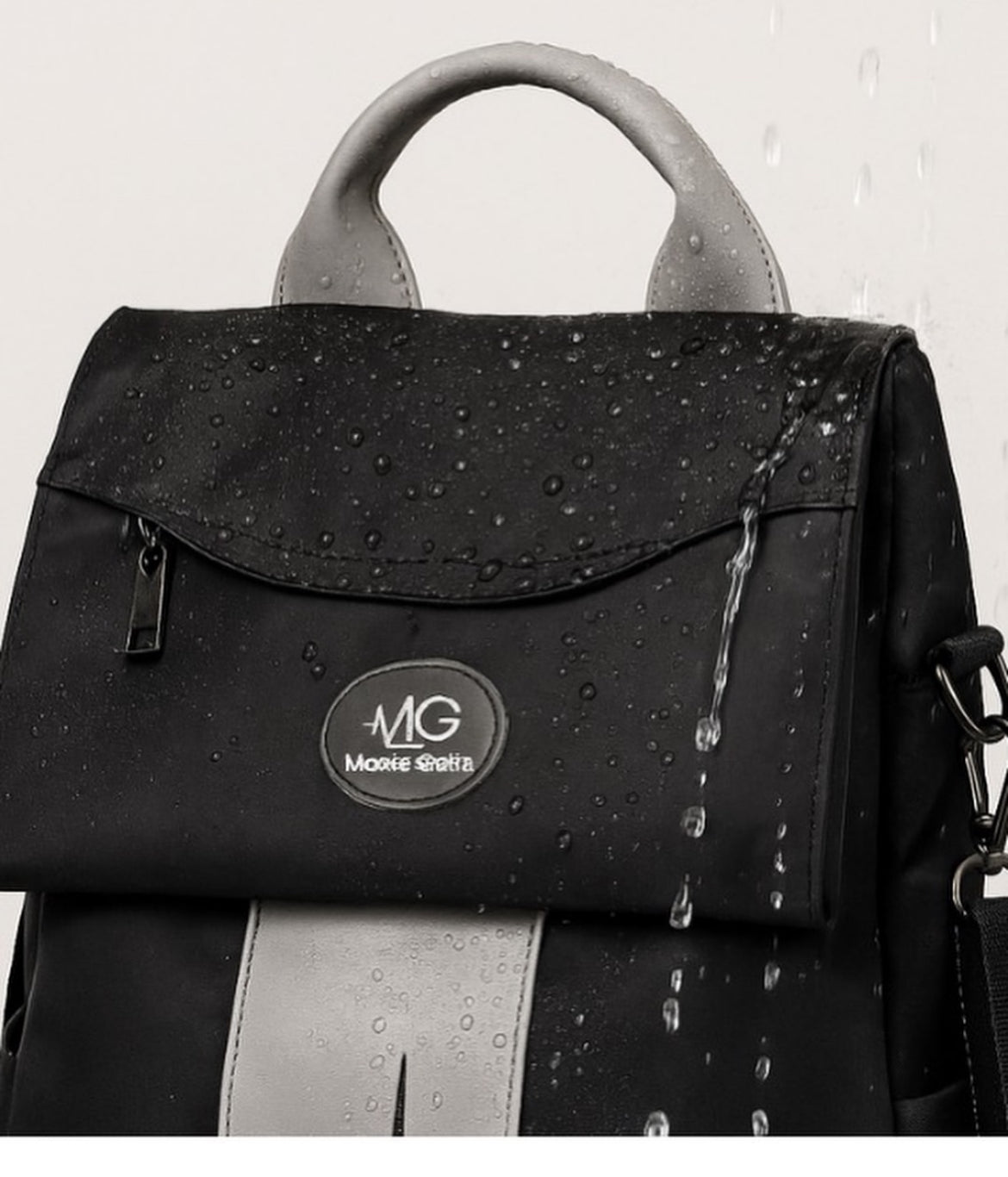 Close-up of MoxieGalia Gidi-Up Lite backpack with water droplets highlighting water-resistant fabric, featuring soft gray handle and ECG panel — designed for all-weather use