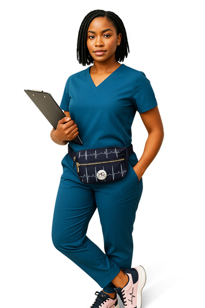 Female model wearing MoxieGalia premium scrubs in deep blue, styled with the MG X-Sentia fanny pack featuring white ECG design, holding a clipboard and striking a confident front-facing pose on white background.