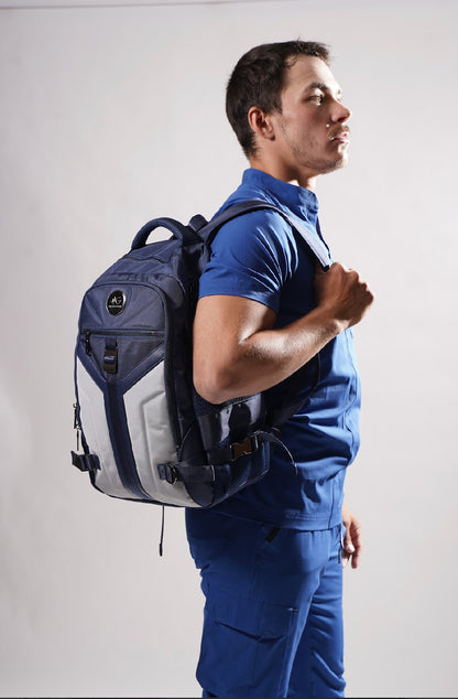 Male model wearing MoxieGalia MG Aviator IJ backpack in navy and gray with moxiegalia premium scrubs, shown against white background — ideal for work, school, or travel”