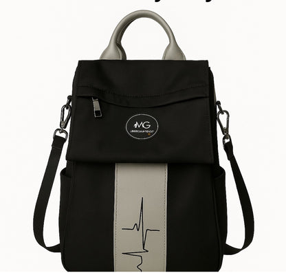 Front view of MoxieGalia Gidi-Up Lite backpack in black with soft beige ECG panel and detachable strap, featuring branded top handle — minimal and functional for everyday carry